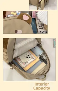 Detail of the khaki backpack showing a spacious interior with multiple items and cute bear ears