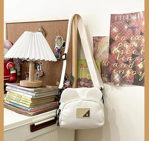 Close-up of a white canvas bag featuring cute 3D bear ears and a stylish square bear patch