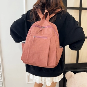 Water-resistant nylon backpack for women in dark pink color with a minimalist design