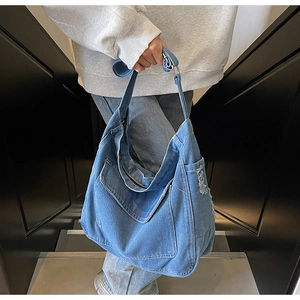 Détail du sac cabas en denim vintage avec bords effilochés et texture délavée