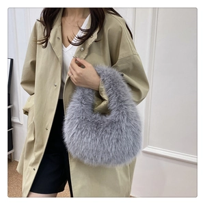 Sac à main en fausse fourrure gris clair porté avec un trench-coat kaki très élégant