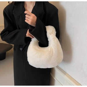 Close-up of fluffy white faux fur texture and smooth handle design on the handbag