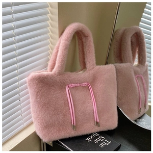 Detail of soft pink plush tote bag featuring elegant drawstring bow and fuzzy texture