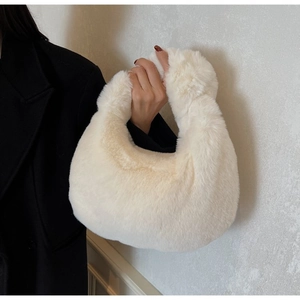 Detail of off-white faux fur handbag with soft texture and minimalist hobo design