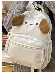 Close-up of cute white cartoon backpack featuring plush ears and embroidered dog face details