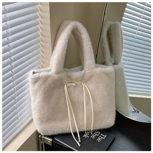 Close-up of soft off-white plush tote bag texture with minimalist metallic buckle detail
