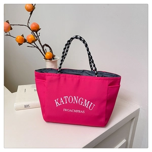Pink tote bag detail with side pockets and black and white woven rope handles