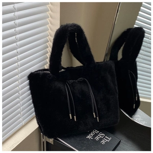 Detail of plush black faux fur tote bag with decorative drawstring and silver metal tips