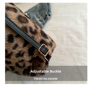 Detail of adjustable black leather strap and gold buckle on leopard faux fur bag