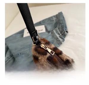 Detailed close-up of leopard faux fur tote with a smooth gold metal zipper and black strap