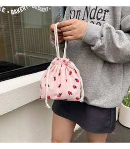 Detail der rosa Cord-Beuteltasche mit süßem Erdbeerdruck und weißem Kordelzuggriff
