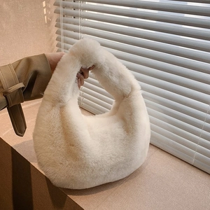 Detail of soft cream faux fur handbag showing rich texture and seamless plush handle