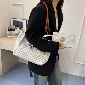 Detailed view of large tote bag with matching pouch featuring letter print and gold hardware