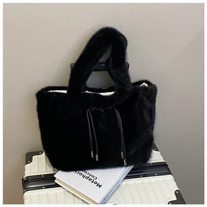 Detailed macro view of the black plush faux fur texture and drawstring on a winter tote bag