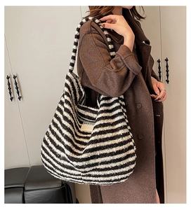 Close-up of a large black and white striped plush tote bag with a soft fuzzy texture