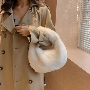 Detail of soft white faux fur handbag styled with a classic autumn trench coat outfit