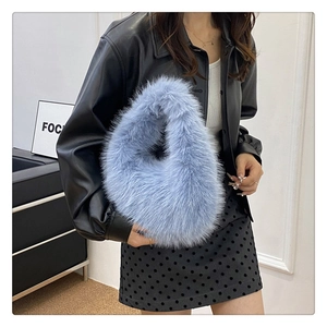 Gros plan sur la texture en fausse fourrure bleu clair et la poignée de ce sac à main élégant
