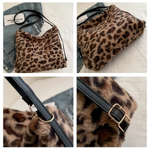 Detail view of leopard print faux fur bag with black leather strap and gold hardware