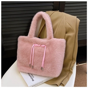Detail of pink faux fur tote bag with satin bow decoration and metallic drawstring tips