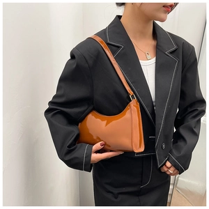 Gros plan sur un sac hobo en cuir verni caramel avec une finition brillante élégante