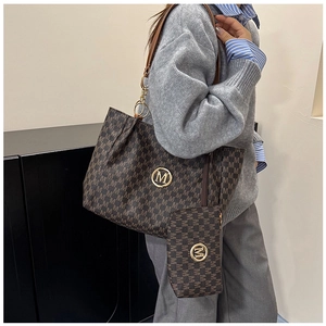 Detail view of large brown tote bag with logo pattern and matching small zipper pouch