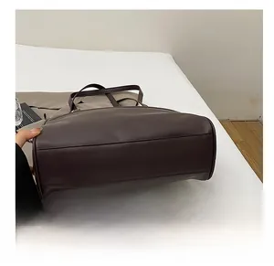 Detailed macro view of the wear-resistant wide base and stitching of the brown leather tote