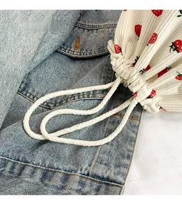 Detail der weichen Cordtasche mit Erdbeermuster und gewebtem Kordelzug-Tragegriff
