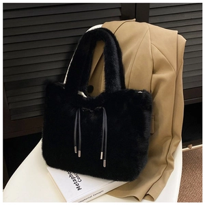 Detail of black faux fur tote bag showing soft plush texture and drawstring metallic tips