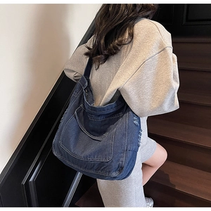 Vue détaillée du grand sac cabas en denim bleu foncé avec des coutures épaisses apparentes