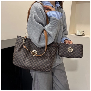 Detail view of the brown monogram tote and clutch set featuring round golden M logo