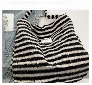 Detailed close-up of soft plaid fleece texture on a casual crescent hobo shoulder bag