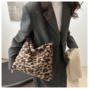 Detail of plush leopard print tote bag with soft faux fur texture and black shoulder strap