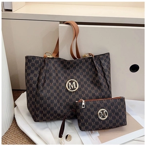 Detailed close-up of dark brown monogram tote bag set with golden metal M logo