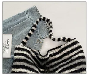 Close-up of black and white striped fuzzy tote bag with textured SEEYOU logo patch