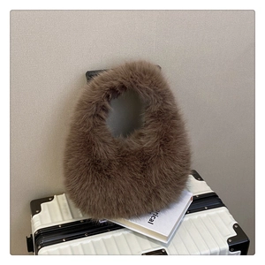 Détail de la texture douce en fausse fourrure marron d'un sac à main en peluche rond