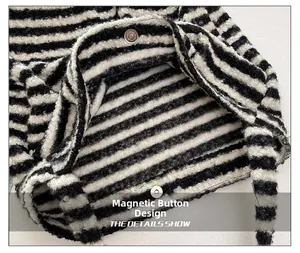 Detail of magnetic snap closure on textured black and white striped sequin bag