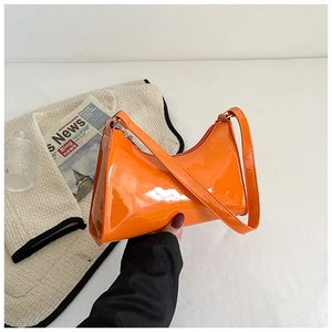 Détail du sac baguette orange vif en cuir verni avec une finition haute brillance