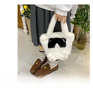 Detail of cute white plush handbag with cat design and pink paw embroidery for women