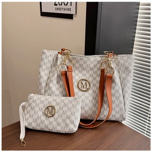 Close-up of the large tote bag set with monogram M pattern and brown leather straps