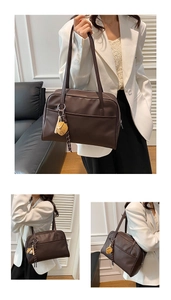 Detail view of the vintage dark coffee tote bag with cartoon charm and smooth leather finish