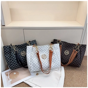 Three large tote bags in black, white, and brown with letter print and metal logo plate