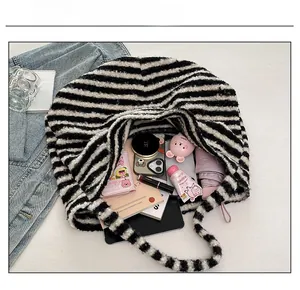 Internal capacity of striped plush tote bag showing storage for tablet and daily items