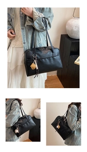 Detail view of black faux leather tote with detachable baseball charms and front pocket