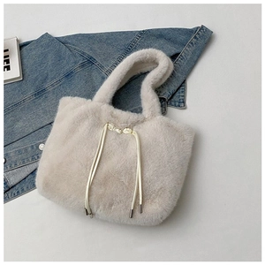 Detail view of plush beige faux fur tote bag with decorative drawstrings and soft handles