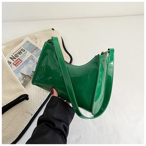Détail d'un sac sous les aisselles en cuir verni vert vif brillant en forme de croissant