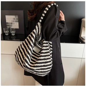Detail view of large knit shoulder bag with black and white stripes and SEEYOU label