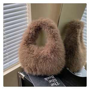 Détail de la texture en fausse fourrure marron et poignée intégrée du sac en peluche