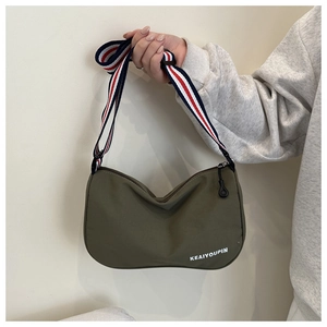 Dettaglio della borsa hobo in nylon verde militare con tracolla larga a righe rosso bianco blu