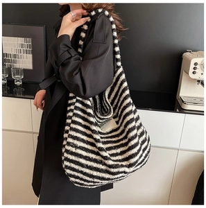 Detailed close-up of a plush black and white striped knit hobo bag with SEEYOU label