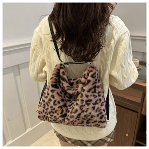 Detail view of pink and brown leopard print plush shoulder bag on female model